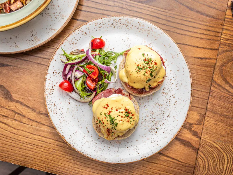 Eggs Benedict auf einem Holztisch