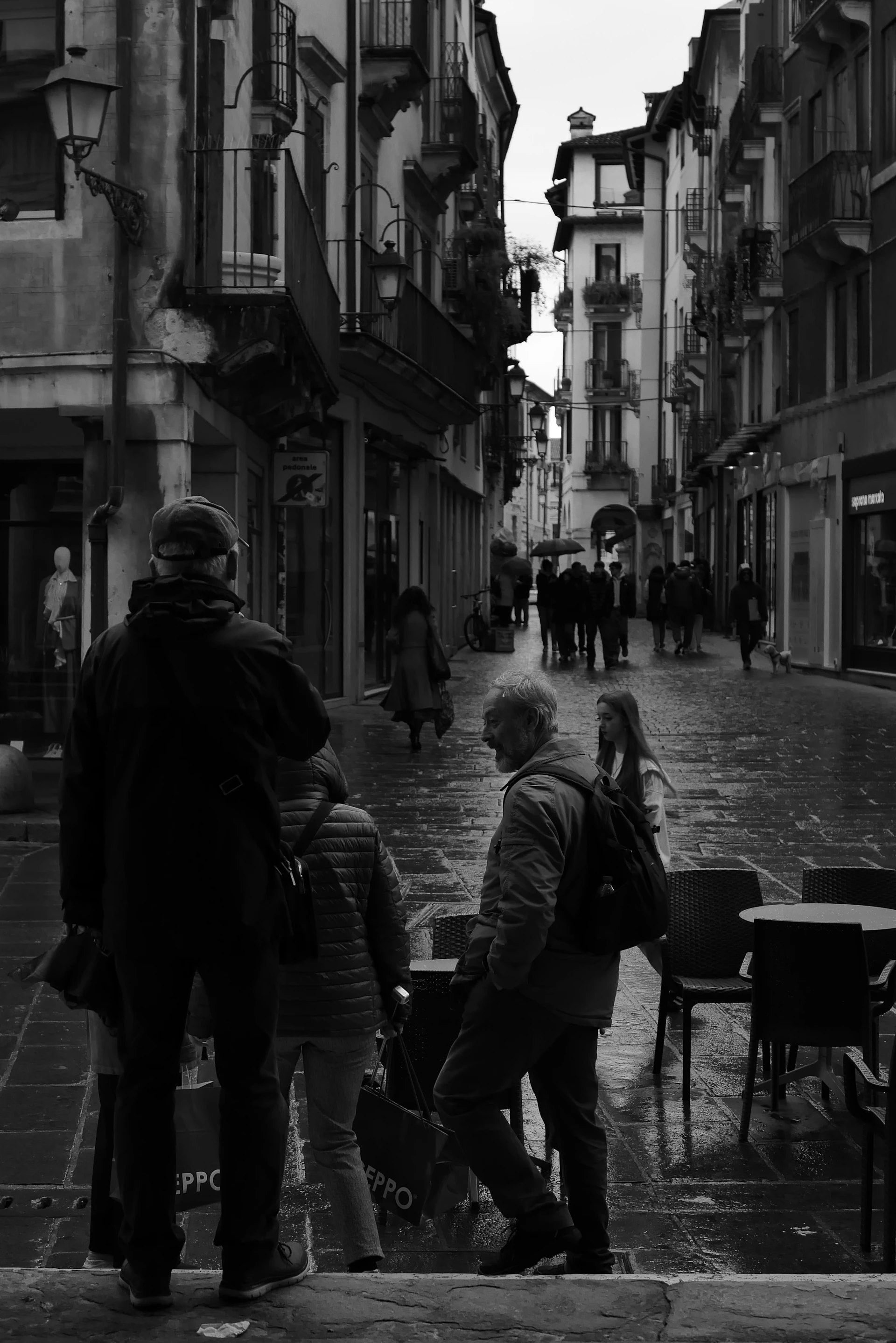 Fußgänger in einer regennassen Altstadtgasse