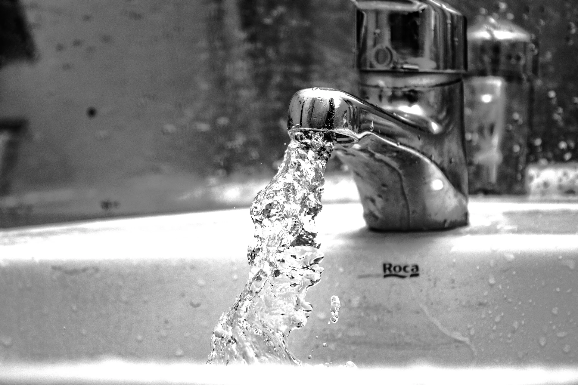 Wasser läuft in Graustufenfotografie aus einem Wasserhahn